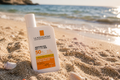 La Roche-Posay Anthelios UV Mune 400 SPF 50+ Invisible Fluid sunscreen bottle resting in sand on a sunny beach