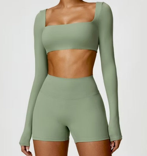 Green athletic outfit with long-sleeve top and shorts on a plain background