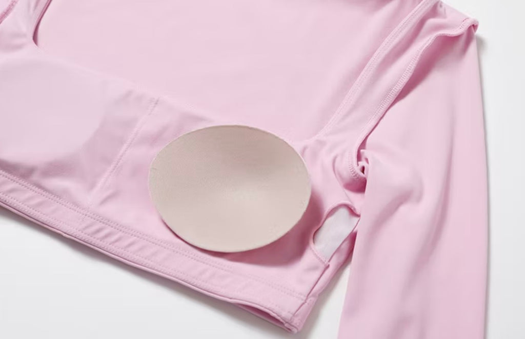Pink fabric with a round white object on a light gray background