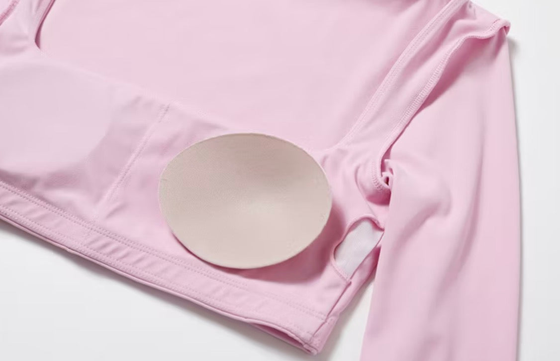 Pink fabric with a round white object on a light gray background