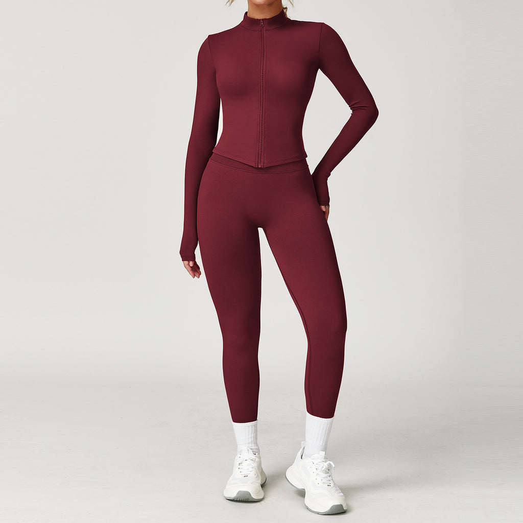Maroon athletic outfit with long-sleeve top and leggings on a plain background