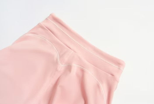 Pink fabric with white stitching on a light gray background
