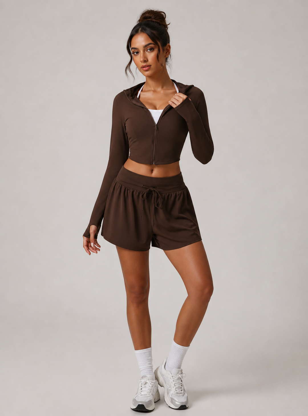 Woman wearing a brown athletic outfit on a plain background